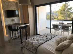 een slaapkamer met een bed en een eetkamer met een tafel bij Au Pied du Pic Saint Loup in Saint-Mathieu-de-Tréviers +7 foto's