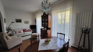 a living room with a dining room table and a couch at Appartamento il roseto Gubbio in Gubbio