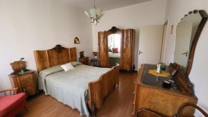 a bedroom with a bed and a dresser and a mirror at Appartamento il roseto Gubbio in Gubbio
