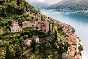 a church on a hill next to the water at AL BOCCALINO Bed & Breakfast Melide Lugano Ticino in Melide