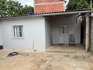 a white house with two chairs and a building at Casa in São Raimundo Nonato