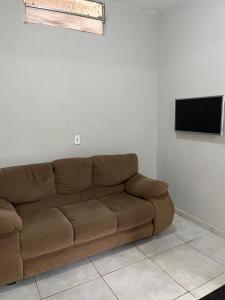 a brown couch in a living room with a flat screen tv at Casa in São Raimundo Nonato