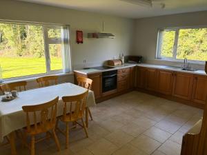 a kitchen with a table and some chairs and a kitchen with a table at Orchard Cottage in Loughgall
