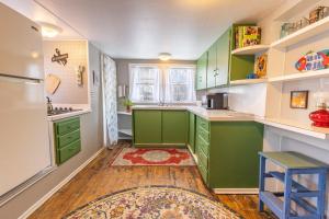 a kitchen with green cabinets and a blue stool at Rustic 2 Bedroom Boho Apartment in Laramie