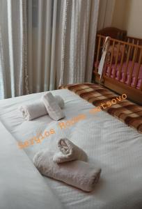 een babybedje met twee handdoeken en een wieg bij Sergios Rooms votonosi metsovo!!! in Votonósion