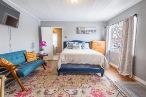 een slaapkamer met een bed, een blauwe bank en een raam bij Charming French Studio Apartment in Laramie