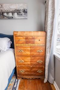 een slaapkamer met een houten dressoir naast een bed bij Charming French Studio Apartment in Laramie