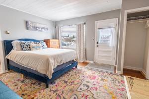 een slaapkamer met een bed, een raam en een tapijt bij Charming French Studio Apartment in Laramie