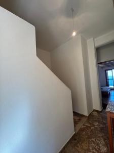 an empty room with a white wall and a table at Cherronisi Apartments in Áyios Andréas