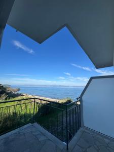 a view of the ocean from the balcony of a house at Cherronisi Apartments in Áyios Andréas