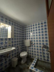 a blue tiled bathroom with a toilet and a sink at Cherronisi Apartments in Áyios Andréas +33 photos
