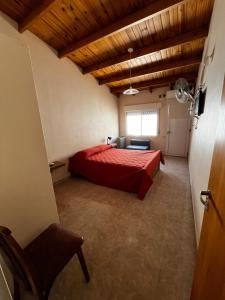 a bedroom with a red bed and a window at Departamentos Valquiria in Monte Hermoso
