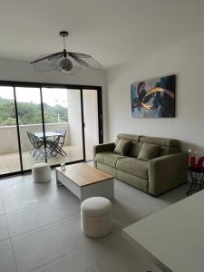 a living room with a couch and a table at Loc A Machja Fiurita 3 appartements - Pietrosella et Ajaccio in Pietrosella