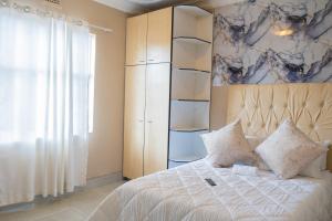 a bedroom with a bed and a large window at Chic Alberton in Alberton