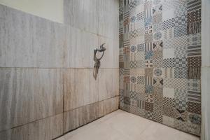 a bathroom with a shower with a tile wall at Collection O Yayah Residence in Bogor +40 photos