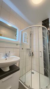 een badkamer met een glazen douche en een wastafel bij Kim Ferienwohnung A in Sömmerda