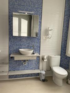 a bathroom with a sink and a toilet and a mirror at El Arca de Noé in Luarca +7 photos