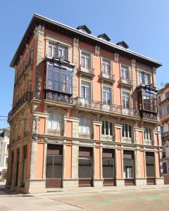 a large brick building with windows on a street at El Arca de Noé in Luarca
