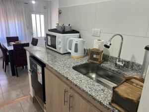 a kitchen counter with a sink and a microwave at Kallpa in Santa Rosa