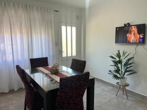 a dining room table with chairs and a tv on a wall at Kallpa in Santa Rosa