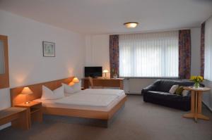een hotelkamer met een bed en een bank bij Pension Landhaus Machold in Friedrichroda