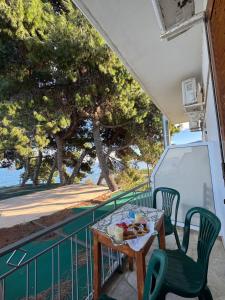a table and chairs on a balcony with a view of the water at Cherronisi Apartments in Áyios Andréas