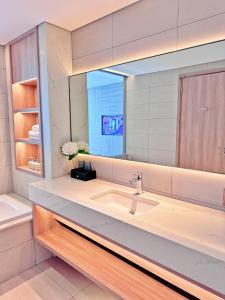 een badkamer met een wastafel en een grote spiegel bij SamSet Corner Seaview Studio A La Carte Ha Long Bay in Ha Long