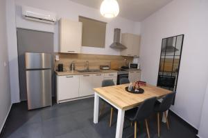 a kitchen with a table and chairs and a refrigerator at The Garage in Tríkala