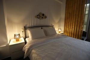 a bedroom with a large white bed with two lamps at The Garage in Tríkala