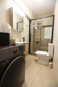 a bathroom with a shower and a washing machine at The Garage in Tríkala