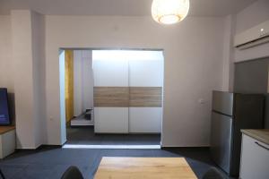 an open door to a kitchen with a refrigerator at The Garage in Tríkala