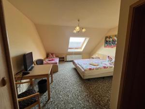 a bedroom with a bed and a desk with a computer at Pension Serbitzer Hof in Serbitz