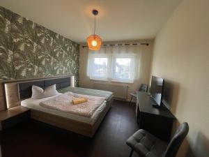 a bedroom with a bed and a desk and a television at Pension Serbitzer Hof in Serbitz