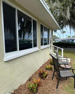 a house with two chairs sitting on the porch at Lakeside Cottages in Lake Placid +2 photos