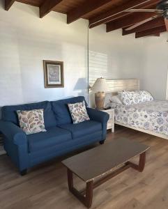 a living room with a blue couch and a bed at Lakeside Cottages in Lake Placid