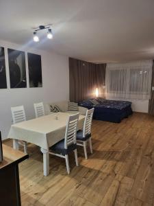 a room with a table and chairs and a bed at Agrobiskupin Kaczmarek in Gąsawa