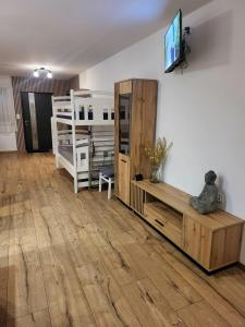 a living room with a television on a wall at Agrobiskupin Kaczmarek in Gąsawa +4 photos