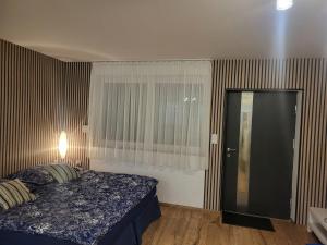 a bedroom with a bed and a window and a door at Agrobiskupin Kaczmarek in Gąsawa