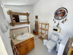 a bathroom with a sink and a toilet and a mirror at Casa Bella Teepees in Zújar