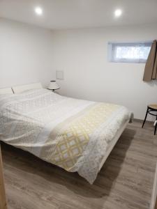 a white bed in a white bedroom with a wooden floor at Chambres d'hôtes en Alsace in Sélestat