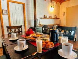 a table with a tray of bread and cups of coffee at Cabañas Alto del Bosque in Coñaripe