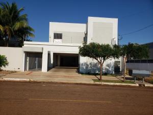 a white building with a garage and a street at Aconchego e paz in Rondonópolis
