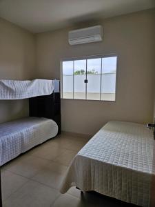 a bedroom with two beds and a window at Aconchego e paz in Rondonópolis