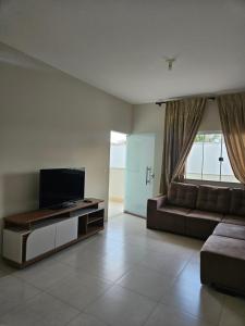 a living room with a couch and a flat screen tv at Aconchego e paz in Rondonópolis