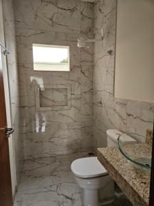 a bathroom with a toilet and a stone wall at Aconchego e paz in Rondonópolis +23 photos