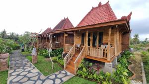 una casa in legno con portico e terrazza di Sirya Farm House a Meliling Altre 18 foto