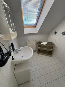 a white bathroom with a sink and a window at Pension Lizzi in Vienna +102 photos