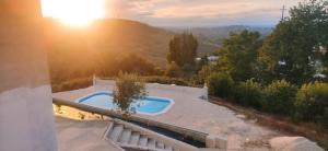 a swimming pool on top of a house with the sunset at Portela ALR in Portela da Memória
