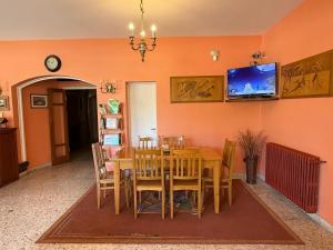 a dining room with a table and a tv on the wall at Hotel Siena Pinamar in Pinamar