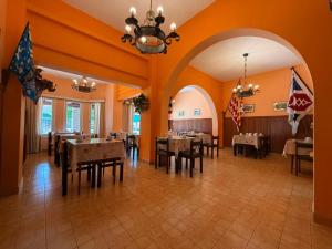 a dining room with tables and chairs and a chandelier at Hotel Siena Pinamar in Pinamar